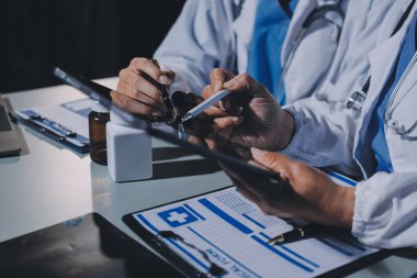 Erkek ve kadın doktorlar bir hastane odasında toplantı yapıyorlar..