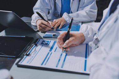 Erkek ve kadın doktorlar bir hastane odasında toplantı yapıyorlar..