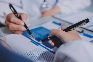 Erkek ve kadın doktorlar bir hastane odasında toplantı yapıyorlar..