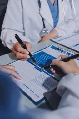 Erkek ve kadın doktorlar bir hastane odasında toplantı yapıyorlar..