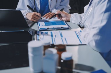 Erkek ve kadın doktorlar bir hastane odasında toplantı yapıyorlar..