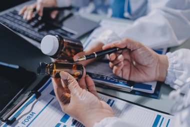 Erkek ve kadın doktorlar bir hastane odasında toplantı yapıyorlar..