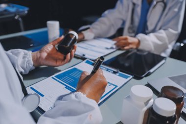 Erkek ve kadın doktorlar bir hastane odasında toplantı yapıyorlar..