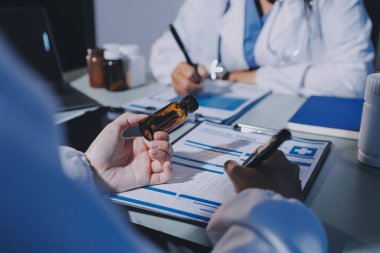 Erkek ve kadın doktorlar bir hastane odasında toplantı yapıyorlar..