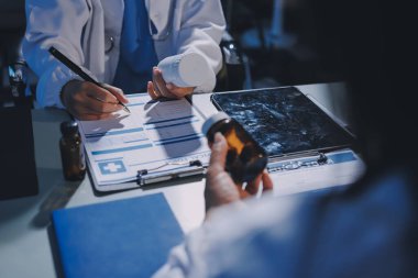 Erkek ve kadın doktorlar bir hastane odasında toplantı yapıyorlar..