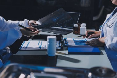 Erkek ve kadın doktorlar bir hastane odasında toplantı yapıyorlar..