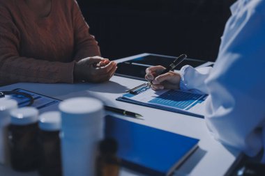 Uzman doktor bir hastaya ilaç götürmeyi açıklıyor. Sağlık ve İlaç danışmanlığı.