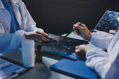 Erkek ve kadın doktorlar bir hastane odasında toplantı yapıyorlar..