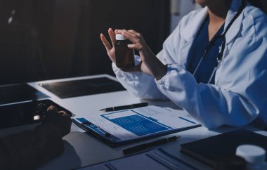 Uzman doktor bir hastaya ilaç götürmeyi açıklıyor. Sağlık ve İlaç danışmanlığı.