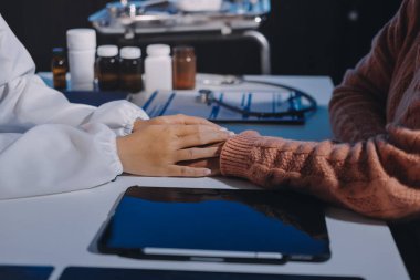 Asyalı kadın elleri yaşlı kadın ellerine dokunuyor hastanede yaşlılara yardım eden eller.