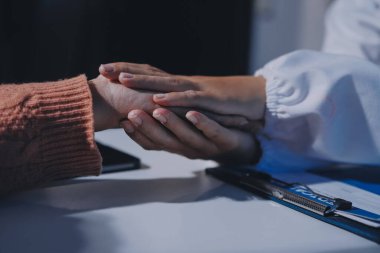 Asyalı kadın elleri yaşlı kadın ellerine dokunuyor hastanede yaşlılara yardım eden eller.