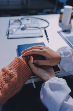 Asyalı kadın elleri yaşlı kadın ellerine dokunuyor hastanede yaşlılara yardım eden eller.