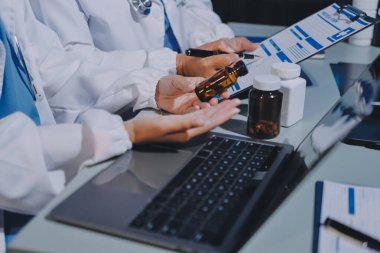 Erkek ve kadın doktorlar bir hastane odasında toplantı yapıyorlar..