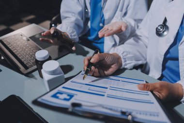 Erkek ve kadın doktorlar bir hastane odasında toplantı yapıyorlar..