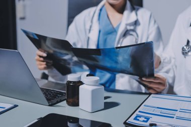 Erkek ve kadın doktorlar bir hastane odasında toplantı yapıyorlar..