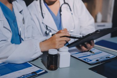 Erkek ve kadın doktorlar bir hastane odasında toplantı yapıyorlar..