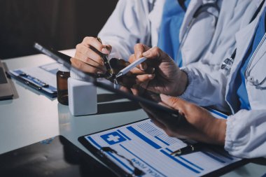 Erkek ve kadın doktorlar bir hastane odasında toplantı yapıyorlar..