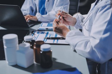 Erkek ve kadın doktorlar bir hastane odasında toplantı yapıyorlar..