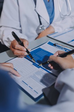 Erkek ve kadın doktorlar bir hastane odasında toplantı yapıyorlar..