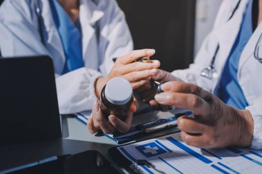 Erkek ve kadın doktorlar bir hastane odasında toplantı yapıyorlar..