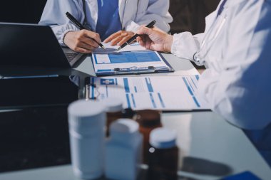 Erkek ve kadın doktorlar bir hastane odasında toplantı yapıyorlar..