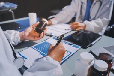 Erkek ve kadın doktorlar bir hastane odasında toplantı yapıyorlar..