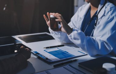 Uzman doktor bir hastaya ilaç götürmeyi açıklıyor. Sağlık ve İlaç danışmanlığı.