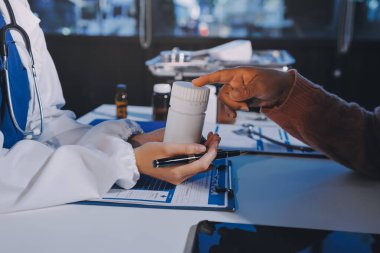 Uzman doktor bir hastaya ilaç götürmeyi açıklıyor. Sağlık ve İlaç danışmanlığı.