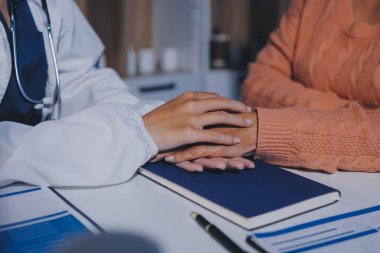 Asyalı kadın elleri yaşlı kadın ellerine dokunuyor hastanede yaşlılara yardım eden eller.