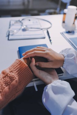 Asyalı kadın elleri yaşlı kadın ellerine dokunuyor hastanede yaşlılara yardım eden eller.