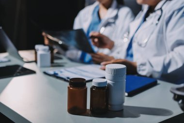 Erkek ve kadın doktorlar bir hastane odasında toplantı yapıyorlar..