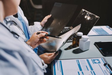 Erkek ve kadın doktorlar bir hastane odasında toplantı yapıyorlar..