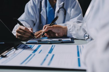 Erkek ve kadın doktorlar bir hastane odasında toplantı yapıyorlar..