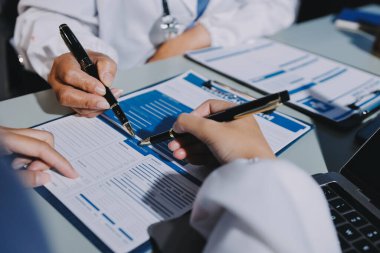 Erkek ve kadın doktorlar bir hastane odasında toplantı yapıyorlar..