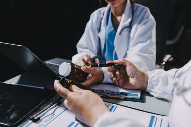 Erkek ve kadın doktorlar bir hastane odasında toplantı yapıyorlar..