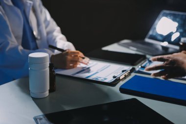 Erkek ve kadın doktorlar bir hastane odasında toplantı yapıyorlar..