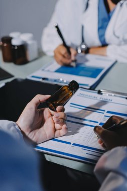 Erkek ve kadın doktorlar bir hastane odasında toplantı yapıyorlar..