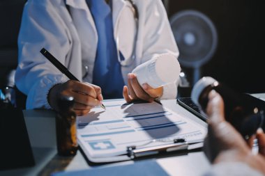 Erkek ve kadın doktorlar bir hastane odasında toplantı yapıyorlar..