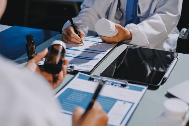 Erkek ve kadın doktorlar bir hastane odasında toplantı yapıyorlar..