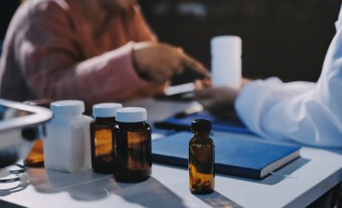 Uzman doktor bir hastaya ilaç götürmeyi açıklıyor. Sağlık ve İlaç danışmanlığı.