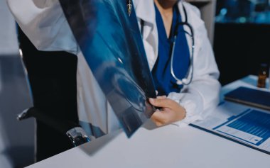 Doktor, emekliye ayrılmış yaşlı kadına akciğer röntgeni çeken hastanın sağlık ve hayat sigortası planlarını kullanarak hastane bakım evindeki hastalara tedavi yöntemlerini anlattı.