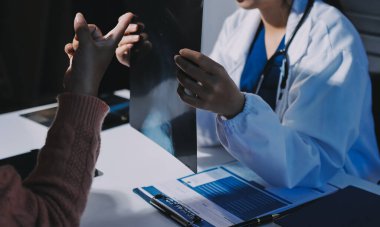 Doktor, emekliye ayrılmış yaşlı kadına akciğer röntgeni çeken hastanın sağlık ve hayat sigortası planlarını kullanarak hastane bakım evindeki hastalara tedavi yöntemlerini anlattı.