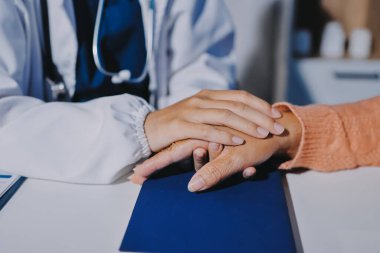 Asyalı kadın elleri yaşlı kadın ellerine dokunuyor hastanede yaşlılara yardım eden eller.