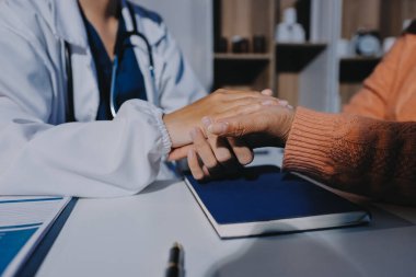 Asyalı kadın elleri yaşlı kadın ellerine dokunuyor hastanede yaşlılara yardım eden eller.