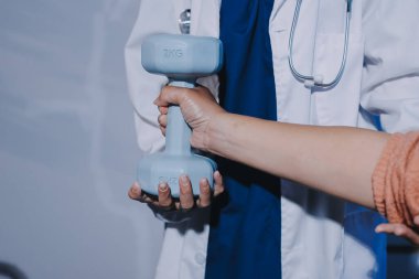 Klinikte dambıllar, fizik tedavi konsepti kullanan hastalarla fizyoterapist eğitimi