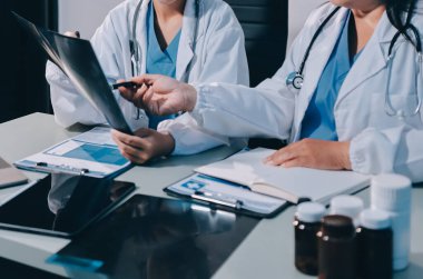 Erkek ve kadın doktorlar bir hastane odasında toplantı yapıyorlar..