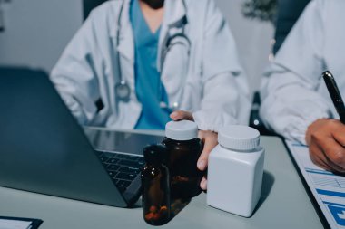 Erkek ve kadın doktorlar bir hastane odasında toplantı yapıyorlar..