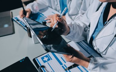 Erkek ve kadın doktorlar bir hastane odasında toplantı yapıyorlar..