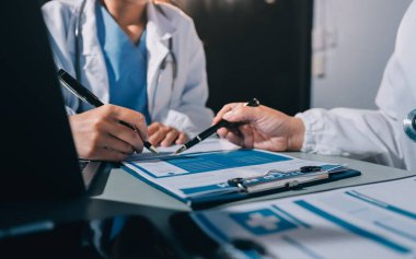 Erkek ve kadın doktorlar bir hastane odasında toplantı yapıyorlar..