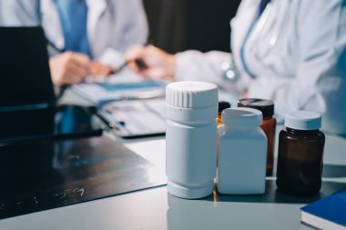 Erkek ve kadın doktorlar bir hastane odasında toplantı yapıyorlar..